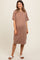 woman wearing a dusty rose short sleeve maternity dress with a pocket and visible baby bump