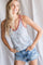 woman wearing a floral print tank top with a v-neckline and distressed denim shorts