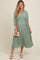woman wearing a mint green pleated maternity dress with a v-neck and flowing sleeves, holding a clutch and showing a baby bump
