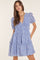 woman wearing a blue floral print tiered mini dress with puff sleeves and side pockets
