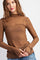 woman wearing a brown polka dot long sleeve top with a high neck and thumbholes, styled with casual jeans