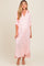 woman wearing a pink and white striped maternity maxi dress with buttons and rolled sleeves, showing her baby bump