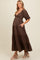 woman wearing a brown tiered maternity dress with short puff sleeves and a baby bump visible
