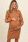 woman wearing a ribbed brown maternity dress with long sleeves and holding her baby bump