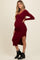woman wearing a burgundy ribbed maternity dress with a side slit and a visible baby bump