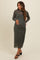 woman wearing a dark green long sleeve maternity dress with ruched detailing and a visible baby bump