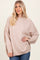 woman wearing a beige oversized sweater with dropped shoulders and long sleeves, paired with blue jeans