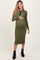woman wearing a green ribbed maternity dress with long sleeves and a front button detail, holding her baby bump