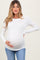 woman wearing a white long sleeve maternity top and holding her baby bump