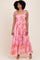 woman wearing a pink floral maxi dress with ruffled straps and a tiered skirt
