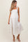 woman wearing a white floral maternity dress with tie straps and a baby bump visible