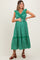 woman wearing a green floral maternity dress with ruffled straps and a tie waist, holding her baby bump