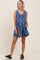 woman wearing a blue floral maternity romper with a tie front and pockets