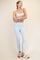 woman wearing a light blue ribbed active legging and a white crop top, standing in a relaxed pose