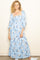 woman wearing a light blue floral maxi dress with puff sleeves and a square neckline.
