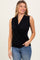 woman wearing a black sleeveless wrap top paired with light blue jeans
