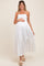 woman wearing a white maternity maxi dress with eyelet details and a smocked bodice, holding her baby bump
