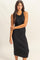 woman wearing a black ribbed knit midi dress with a sleeveless design and a fitted silhouette