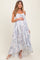 woman wearing a flowy white floral maternity maxi dress with adjustable straps and a baby bump visible