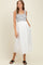 woman wearing a striped maternity dress with a white skirt and pockets, featuring a fitted bodice and flowing design