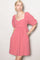 woman wearing a pink short sleeve dress with a square neckline and puff sleeves, featuring side pockets