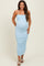 woman wearing a light blue ribbed maternity dress with spaghetti straps and a visible baby bump