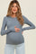 woman wearing a grey long sleeve maternity top and holding her baby bump