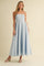 woman wearing a light blue spaghetti strap maxi dress with a fitted bodice and flowy skirt