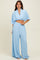 woman wearing a light blue two-piece set with a cropped top and wide-leg pants