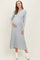 woman wearing a light gray ribbed long sleeve maternity dress and holding her baby bump