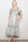 woman wearing a silver puff sleeve maxi dress with a square neckline and pockets