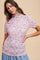 woman wearing a pink sheer floral mesh top with a high neck and short sleeves