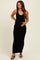 woman wearing a black ribbed maternity maxi dress and holding her baby bump