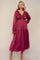 woman wearing a burgundy long sleeve tiered maxi dress with a v-neckline and ruffle details