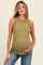 woman wearing a light olive green maternity tank top with ruffle details and a visible baby bump