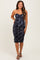 woman wearing a dark blue strapless maternity dress with ruched detailing, standing and smiling