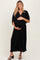 woman wearing a black ribbed maternity maxi dress and holding her baby bump