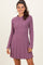 woman wearing a purple ribbed long sleeve dress with a flared skirt and knit texture