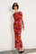 woman wearing a vibrant off-the-shoulder floral maxi dress with long sleeves and black pointy-toed shoes