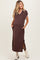 woman wearing a brown maternity maxi dress with a collar, side slits, and pockets, showing her baby bump