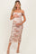 woman wearing a floral print maternity dress with off-shoulder sleeves and a visible baby bump