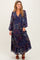 woman wearing a navy floral maternity maxi dress with long sleeves and a tiered skirt, showcasing her baby bump