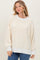 woman wearing a cream and gold striped oversized sweater with balloon sleeves and a relaxed fit