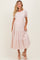 woman wearing a pink and white striped maternity dress with short sleeves and a tiered skirt, holding her baby bump