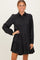 woman wearing a black button-up tiered dress with long sleeves and a collared neck