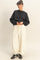 woman wearing a black oversized sweater and cream drawstring sweatpants with a relaxed fit