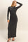 woman wearing a black long sleeve fitted maxi dress with a high neck and a sleek silhouette