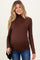 woman wearing a brown long sleeve turtleneck maternity top and showing her baby bump