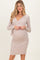 woman wearing a beige long sleeve maternity wrap dress and showing her baby bump