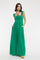 woman wearing a green maxi dress with ruffled straps and side pockets, standing against a white background